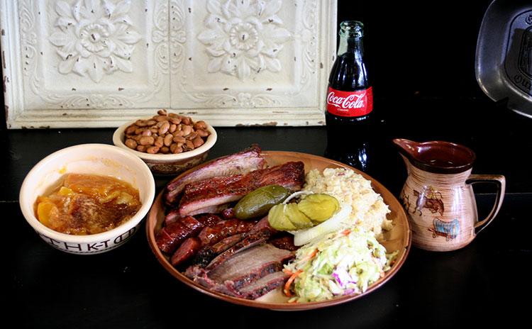 A delicious meal at McKenzie's including barbeque, slaw, beans, and coke classic.
