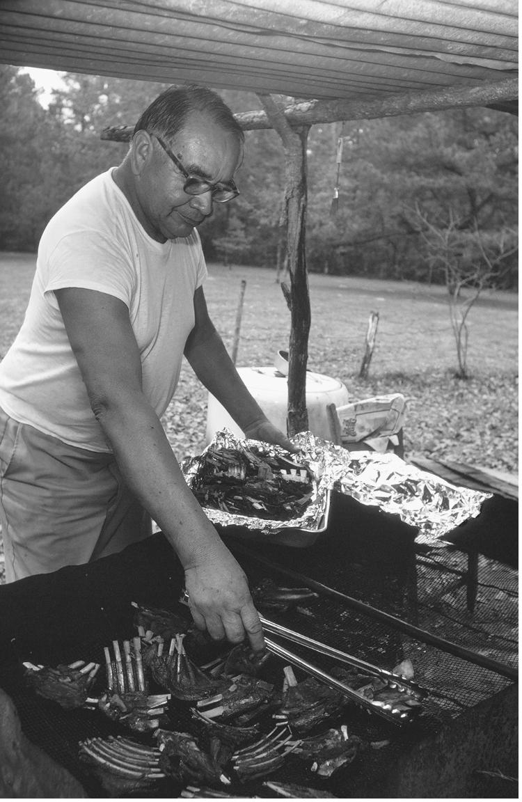 The late chief Robert Fulton Battise barbecuing venison ribs for his communal meal of Thanksgiving.